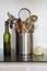 Silver container of kitchen utensils with oil bottle and onion