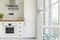 Silver cooker hood above wooden countertop in white kitchen inte