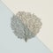 Silver coral fan sculpture on pastel blue-ivory background. 3d