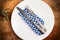 Silver cutlery on blue and white squared napkin