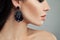 Silver earrings with gems. Perfect woman closeup profile