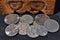 Silver Escudo coins of Portugal in front of a wooden box