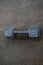 A Silver Fifteen Pound Dumbbell on Concrete