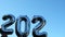 Silver foil number 2023 change to 2024 celebration new year balloon on blue sky background. Happy New year greetings
