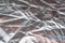 Silver foil shiny fabric texture background, wrapping scratched foil for wallpaper decoration element with selective focus