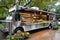 A silver food truck is parked in front of a tree, serving customers with delicious food, Elegant food truck serving gourmet