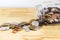 Silver and gold coin pour from grass jar bottle on wood table with white background