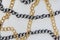 Silver and gold color chains. Chains on white leather background