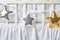 Silver, gold and white star shaped pillows on a white baby cot