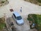 Silver hatchback car, walking man and drinking fountain in the square, top view. Creative aerial photo, road surface with copy