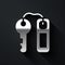 Silver Hotel door lock key with number tag icon isolated on black background. Long shadow style. Vector