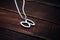 a silver infinity sign necklace on a dark wooden table