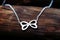 silver infinity sign necklace laying on a dark wood surface
