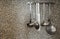 Silver kitchen tools old gray rustic wall background, Rack with clean kitchenware