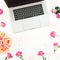 Silver laptop, roses flowers and marshmallow on white background. Flat lay. Top view. Women`s blog concept