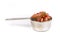 Silver measuring cup containing fruit cake mix side view