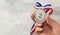 Silver medal. The second place award with a ribbon a man holds in his hand