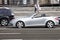 Silver Mercedes Benz convertible in town. Car in motion