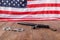 silver metal handcuffs and police nightstick near US flag on wooden surface