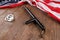 silver metal handcuffs and police nightstick near US flag on wooden surface