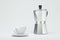 Silver moka pot and white coffee cup on white background. 3d rendering.