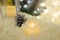 Silver painted pine cone on Merry Christmas and Happy New Year background. Candle standing on white fur carpet.
