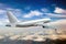 Silver passenger plane iflies high above the clouds. Back view of aircraft