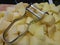 Silver potato peeler on chopped potatoes