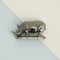 Silver rhinioceros sculpture on pastel blue-ivory background. 3d rendering