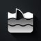 Silver Shark fin in ocean wave icon isolated on black background. Long shadow style. Vector