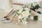 Silver shoes of the bride , perfume, bouquet and wedding rings on the dressing table near the mirror.