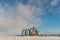 Silver silos against the blue sky in winter. Grain storage in winter at low temperatures. A wheat field covered with snow, the