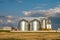 Silver silos on agro manufacturing plant for processing drying cleaning and storage of agricultural products, flour, cereals and
