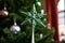 a silver star topper on a green christmas tree