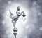 Silver statue of angel hold the lamp on the bokeh background