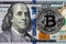 Silver symbolic coin Bitcoin on banknotes of one hundred dollars. Exchange bitcoin cash for a dollars