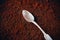 A silver teaspoon lies on the fragrant ground coffee. Instant invigorating coffee in the morning. Love of coffee