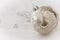 Silver textured christmas bauble on white patterned background