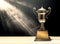 silver trophy placed on wooden table with dark background copy s