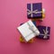 Silver, violet and blue christmas boxes on a pink background