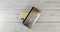 Silver wallet with black clasp and an expensive smartphone with two cameras on a wooden board background. Top view