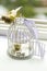 Silver wedding rings and engagement ring in decorative cage of bird