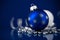 Silver, white and blue christmas ornaments on dark blue background. Merry christmas card.