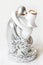 Silver and white figurine of couple - man and woman - with golden wedding rings