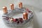 Silver wicker-work advent wreath with bronze coloured candles and christmass decoration
