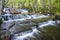 Silverfallet staricase Waterfall in Lush forest and rural mill environment