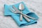 Silverware and hemstitch napkin on antique carrara marble