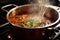 simmering bolognese sauce, steam rising from the pot