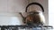 Simmering whistling kettle on the old stove.