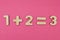 Simple arithmetic for children. One plus two - three on a bright pink background